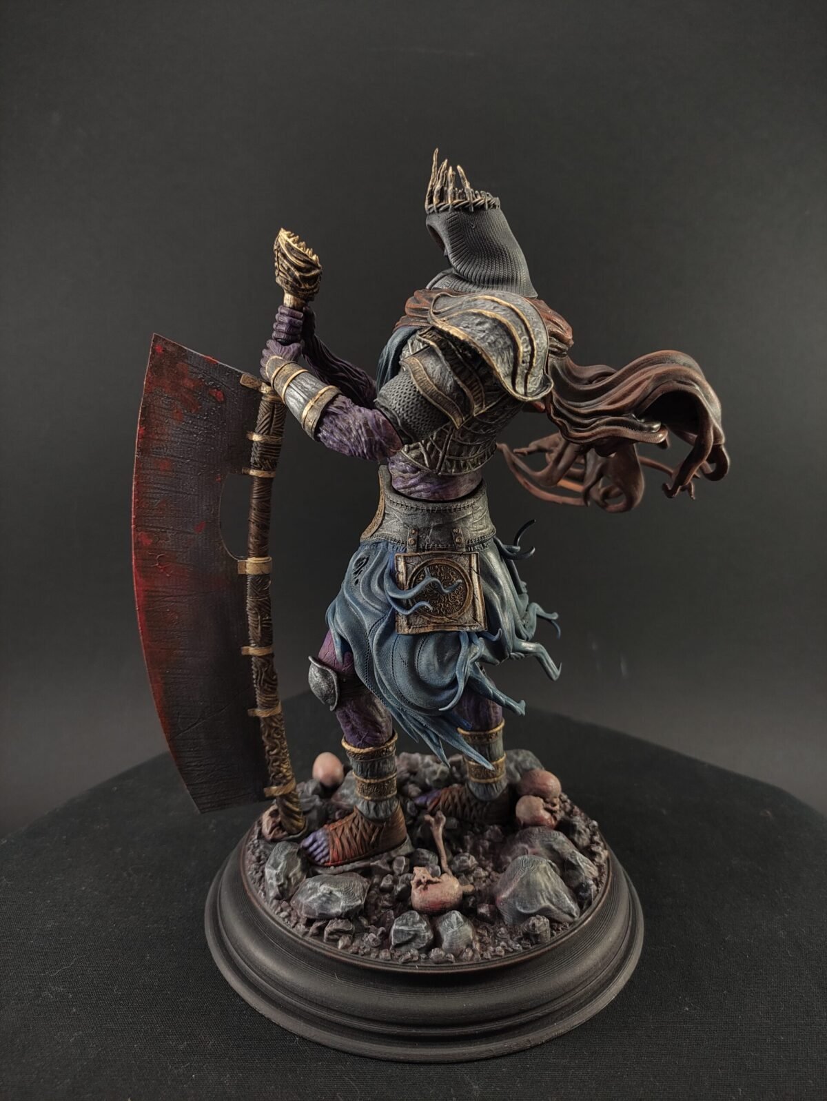 Left profile of seated Yhorm figure with draped cloak and detailed gauntlets