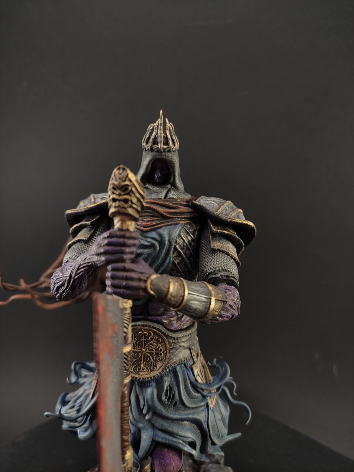 Side view of Yhorm resin figure seated with great machete resting beside cloak