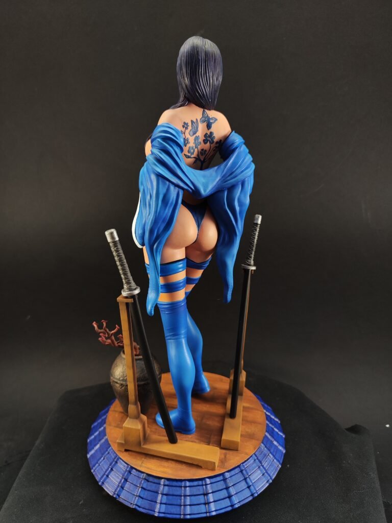 Back view of figure with sculpted hair, sash motion, and painted details