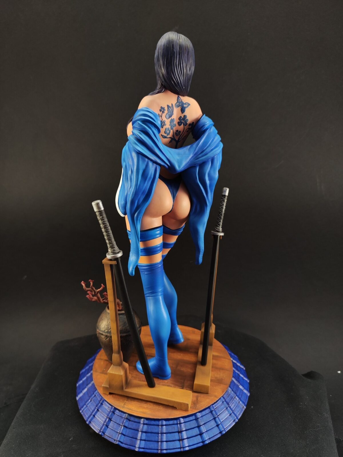 Back view of figure with sculpted hair, sash motion, and painted details