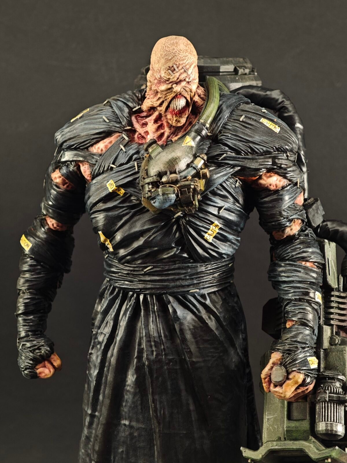 Angled front shot showing stitched face, tactical boots, and torn black coat