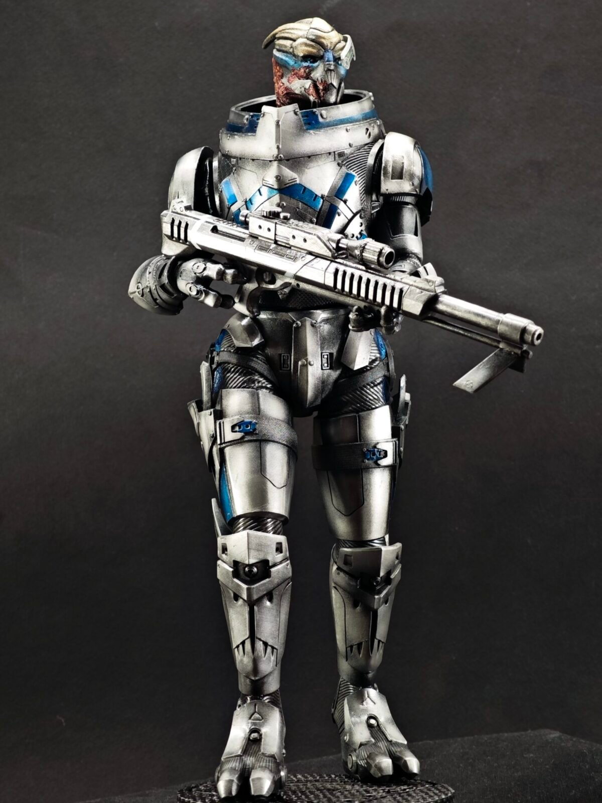 Low side angle showing rifle, armor texture, and stance balance