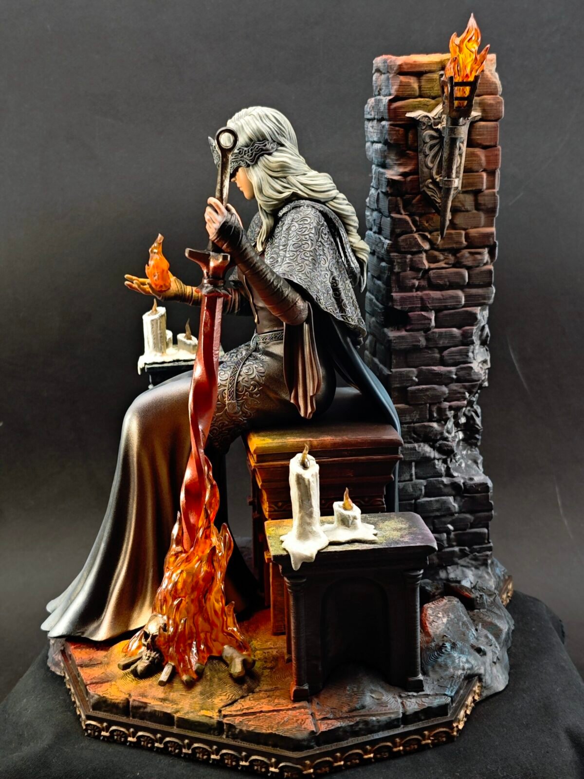 Left profile of Fire Keeper figure showing sculpted cloak folds and hand pose