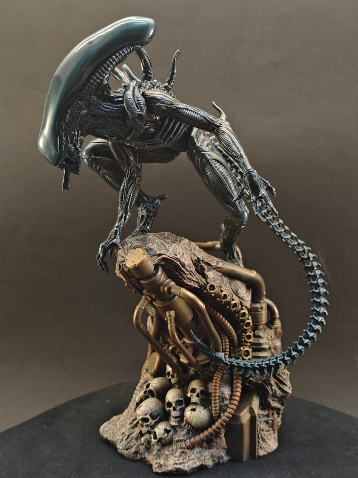 Left profile of alien figure highlighting head crest and bent leg posture