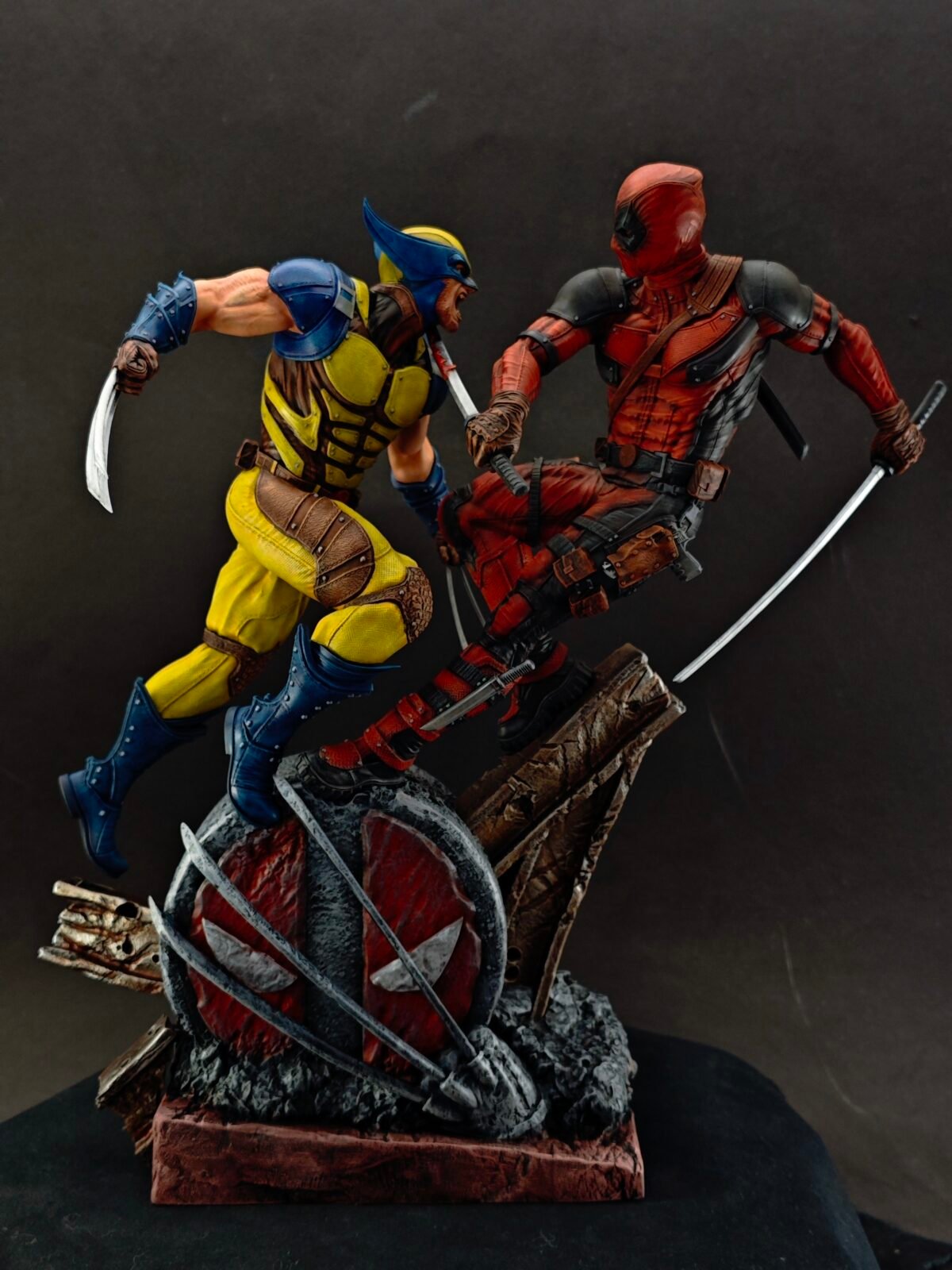 Side view of red-suited fighter clashing with clawed warrior on rocky diorama base